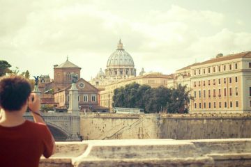 Turista sul ponte Sant'Angelo di Roma fotografa San Pietro